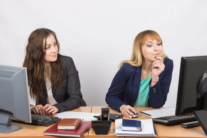 Office worker looking with distaste at the colleague sitting next